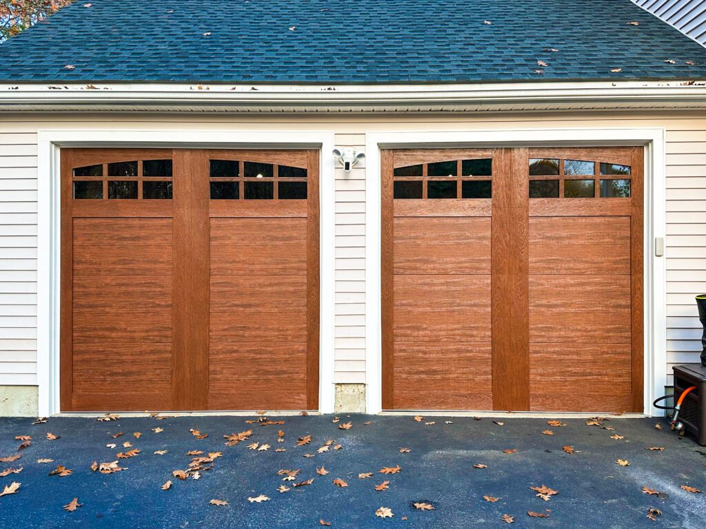 Two side by side wood-tone carriage house garage doors